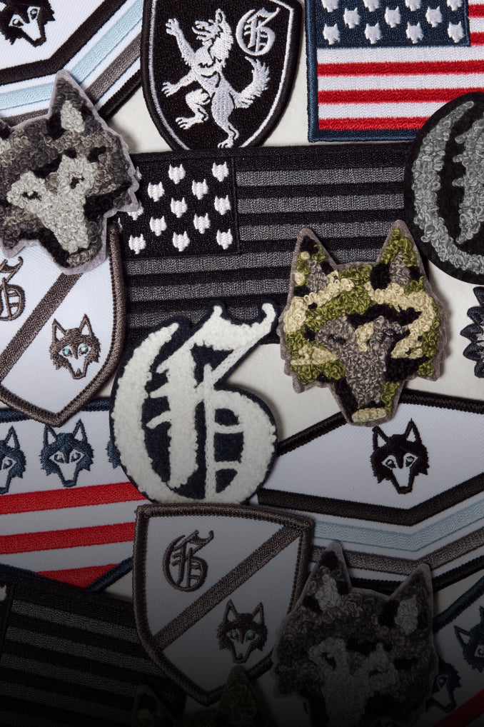 Collection of patches with various designs including flags and animal symbols on a textured surface.