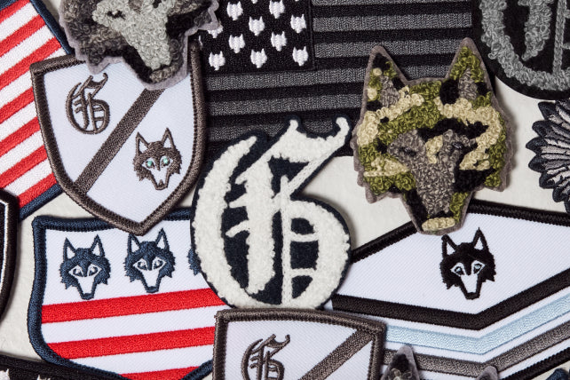 Collection of military-style patches featuring wolves and American flags.