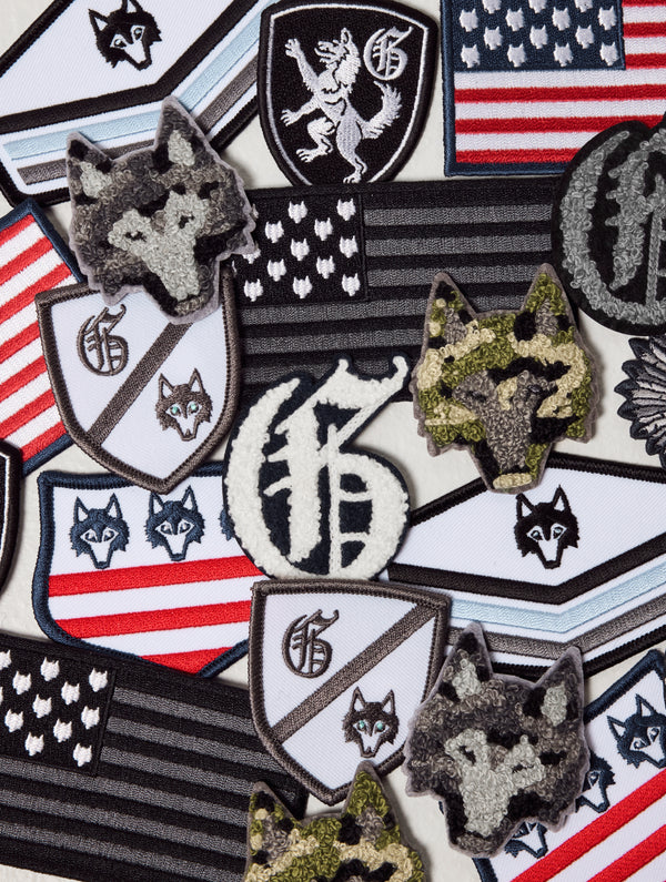 Collection of patches featuring wolves, American flags, and symbols on a textured background.